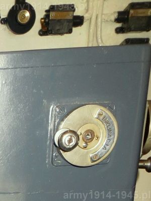45. ORP Błyskawica, zbliżenie na pokrętło inklinacji kalkulatora FCB umieszczonego w centrum centrali. W tle widok na przełączniki na przedniej ścianie centrali. 