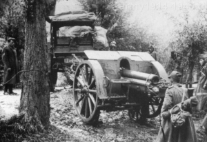 Rok 1940/1941, Albania - Front włosko-grecki. Ciągnik artyleryjski Pavesi holuje haubicę 100/17 mod.914 umieszczoną na wózku transportowym po błotnistej drodze.