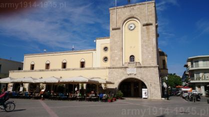 Wybudowany w latach 1934-1935 dom faszyzmu (Casa del Fascio) w Kos. Budynek ma przyległe kino a dla faszystów miał też być miejscem spotkań i wypoczynku po pracy. Obecnie zmienił przeznaczenie. (Isola Coo)
